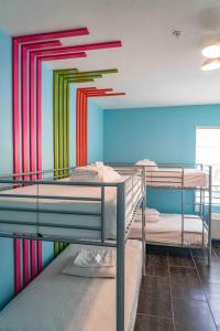 迈阿密海滩住宿加饮品酒店的客房设有两张双层床和色彩缤纷的墙壁。