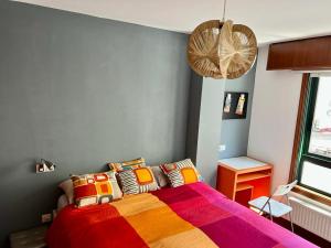 拉科鲁尼亚Apartamento zona Ria do Burgo的一间卧室配有一张带彩色毯子的床