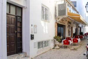阿尔布费拉Sofeelings, Estudio Sol, Baixa de Albufeira的街上一家餐厅,有红色的桌椅