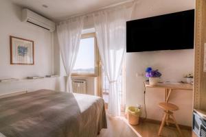 奇维塔韦基亚卡萨苏尔马尔住宿加早餐旅馆的一间卧室设有一张床和一个大窗户