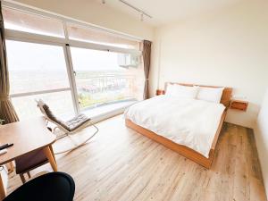 东港艾睏khùn行旅的一间卧室设有一张床和一个大窗户
