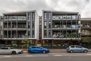 墨尔本Lovely 2 bedroom unit in North Melbourne - 03068的停在大楼前的三辆汽车