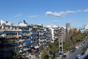 雅典La Residence Athens的一条拥有高楼公寓建筑和汽车的城市街道