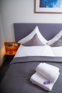 弗希塔HOTEL BREMER TOR, Bestes Hotelfrühstück, Self-Check-In 24 h的一间卧室配有一张带两个白色枕头的床