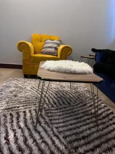 达累斯萨拉姆Romantic, Stunning & Authentic Ensuited Master Bedroom的客厅配有黄色沙发和地毯。