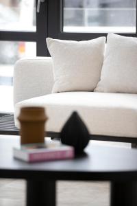 蒂米什瓦拉Cosmopolita Boutique Hotel的客厅配有沙发和一张桌子及一本书