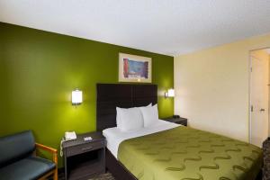西塔科Quality Inn SeaTac Airport-Seattle的酒店客房,设有一张带绿色墙壁的床