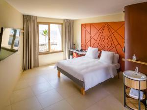 PamandziIbis Styles Mayotte Aéroport的卧室设有一张白色大床和一扇窗户。