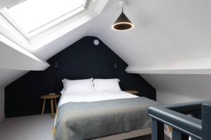 LlanddyfnanA Beautiful 3 Bedroom 17th Century Stone cottage的卧室设有黑白床和窗户。