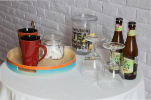 SoigniesLes Greniers de Madelgaire的一张桌子,上面放着瓶装啤酒和眼镜