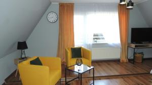 SikorzynoZielone Tarasy na Kaszubach的客厅配有2把黄色椅子和窗户
