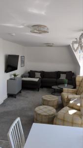 米尔波特Wee Cumbrae View的客厅配有沙发、椅子和电视