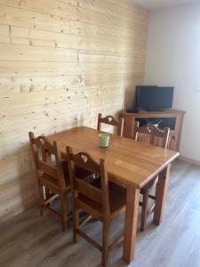 格尔姆Appartement 4 personnes - Hautes-Pyrénées- Village de Peyragudes Peyresourdes - Vue exceptionnelle sur la montagne的一张木桌和椅子