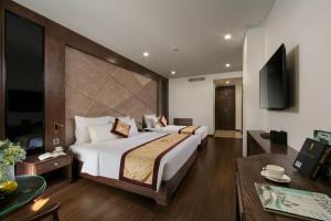 下龙湾Halios Luxury Halong Hotel的一间带大床的卧室和一间客厅
