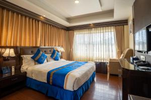 加德满都Shangrila Blu Hotel的酒店客房设有一张大床和一张书桌。