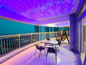 绥中滨海小院的阳台配有桌椅和紫色灯