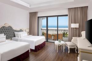 格卢市社Melia Vinpearl Cua Hoi Beach Resort的酒店客房设有两张床和一个阳台。