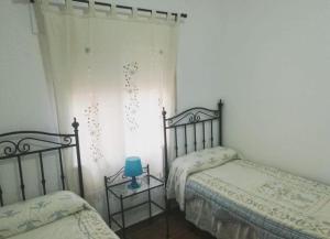 波萨达斯Dama Rural的一间卧室设有两张床,一张桌子上放着蓝色蜡烛