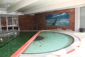 弗瓦迪斯瓦沃沃Apartament Patio 50 m od plaży的一座大型游泳池,位于一座建筑中,拥有绿色的海水