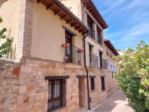 阿尔克萨尔La Cocineta - Zaracatralla的一座古老的石头建筑,在街上设有阳台