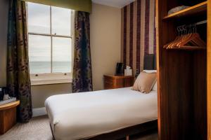 兰迪德诺Esplanade Hotel Llandudno的一间卧室设有一张床和一个海景窗户