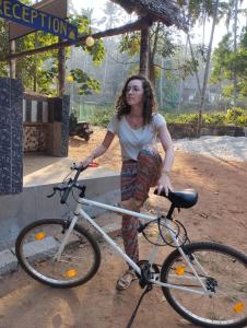 瓦尔卡拉Molly's Hostel的一位妇女站在自行车旁边