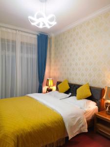 丽江丽江妈妈纳西家庭客栈的一间卧室配有黄色床和黄色枕头
