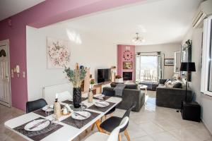 阿尔戈斯托利翁Nikos Apartments Spacious and Panoramic的用餐室以及带桌椅的起居室。