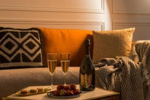 巴黎My Opéra的沙发上的一瓶香槟和两杯酒