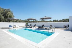 拉多斯VillaPhysis with Private Pool的一座大楼内的游泳池,配有椅子和遮阳伞