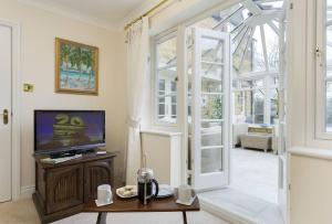 奇平卡姆登Chipping Campden - Cotswolds private house with garden的带电视的客厅和带窗户的客厅。