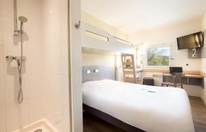 弗雷瑞斯Ibis Budget Fréjus Capitou的酒店客房设有一张白色的床和淋浴。