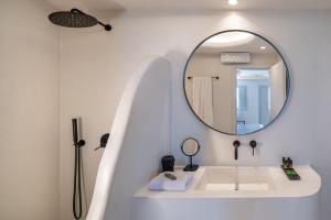 易莫洛林Akra Suites & Spa的白色的浴室设有水槽和镜子