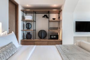 易莫洛林Akra Suites & Spa的卧室配有白色的床和电视。