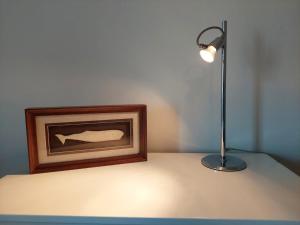 英雄港Charme Apartment Center的一张桌子上的一盏灯,放在一张照片旁边