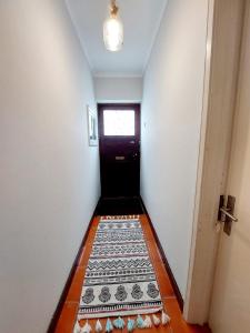 英雄港Charme Apartment Center的走廊设有黑色门,铺有瓷砖地板