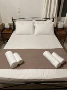 普洛马里翁Garden house No1的一张带两个枕头的床和两条毛巾