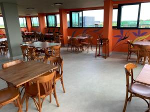 嘎林海斯港Pousada Amada Terra的餐厅设有桌椅和窗户。