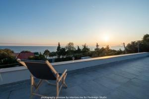 尼尔斯吉尼Wine After Sun Sea Front Villa的屋顶上坐着椅子,享有日落美景