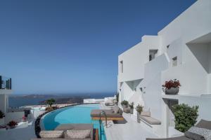 易莫洛林Akra Suites & Spa的享有带游泳池的白色建筑的景致