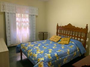 新弗里堡Recanto dos Herdy´s的一间卧室配有一张带蓝色棉被的床和窗户。