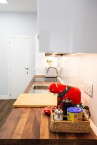 马德里Apt nuevo! 2 hab, baño doble, garaje, Metro a 200m的木桌上配有红色用具的厨房