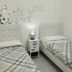圣玛丽亚纳瓦雷Guest House Oleandro IUN 2727的一间卧室配有两张床和床头灯。