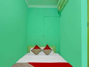 秾莎OYO 92496 Faraas Homestay Syariah的一间卧室配有一张带两个红色枕头的床