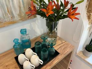 干尼亚Antica Canea Luxury Rooms的一张带蓝色玻璃花瓶的桌子和一个花瓶