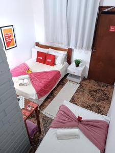 皮雷诺波利斯Pousada Torre dos Mouros的宿舍间内的两张床,配有红色枕头