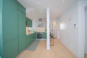 卡斯卡伊斯Central & Stylish 2 Bedroom Apartment w/ Balcony的厨房配有绿色橱柜和白色墙壁