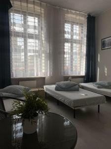 卡托维兹Hostel Kamienica Rynek 7的带两张床和玻璃桌的房间