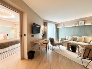 迪纳尔Emeria Dinard Thalasso Spa - Avril 2024 Réouverture après rénovation的酒店客房配有床、沙发和桌子。