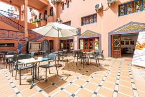 马拉喀什Hotel Oudaya & Spa的一个带桌椅和遮阳伞的庭院
